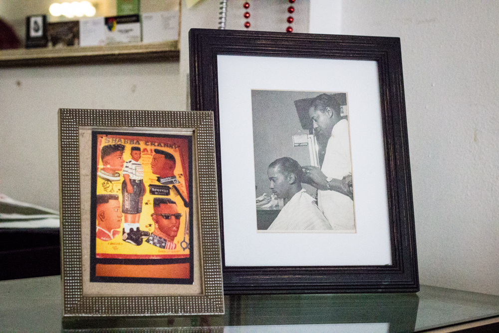 Framed vintage photos in the shop, including a black-and-white photo of a barber at work